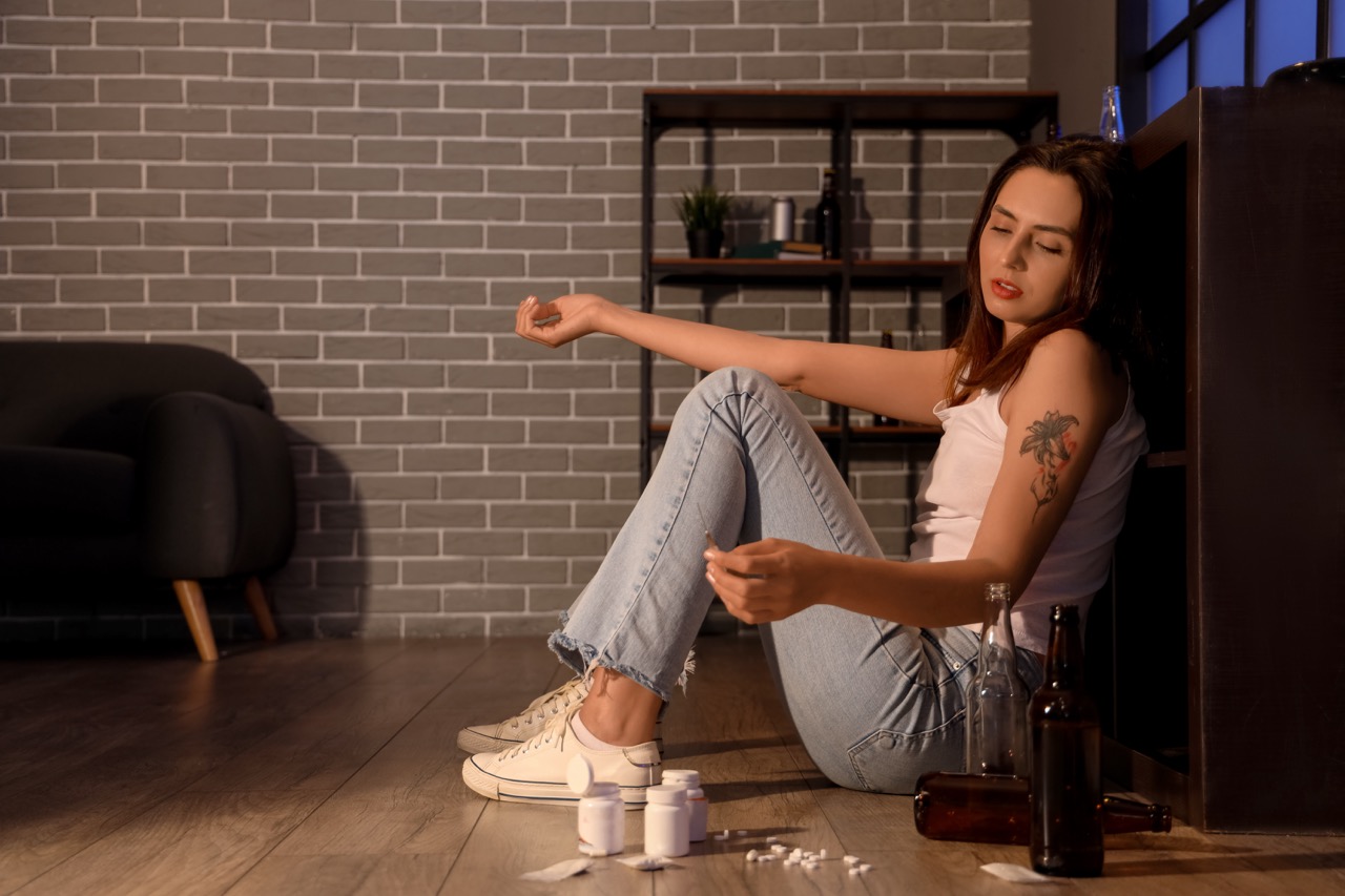Female drug addict with syringe at home in evening